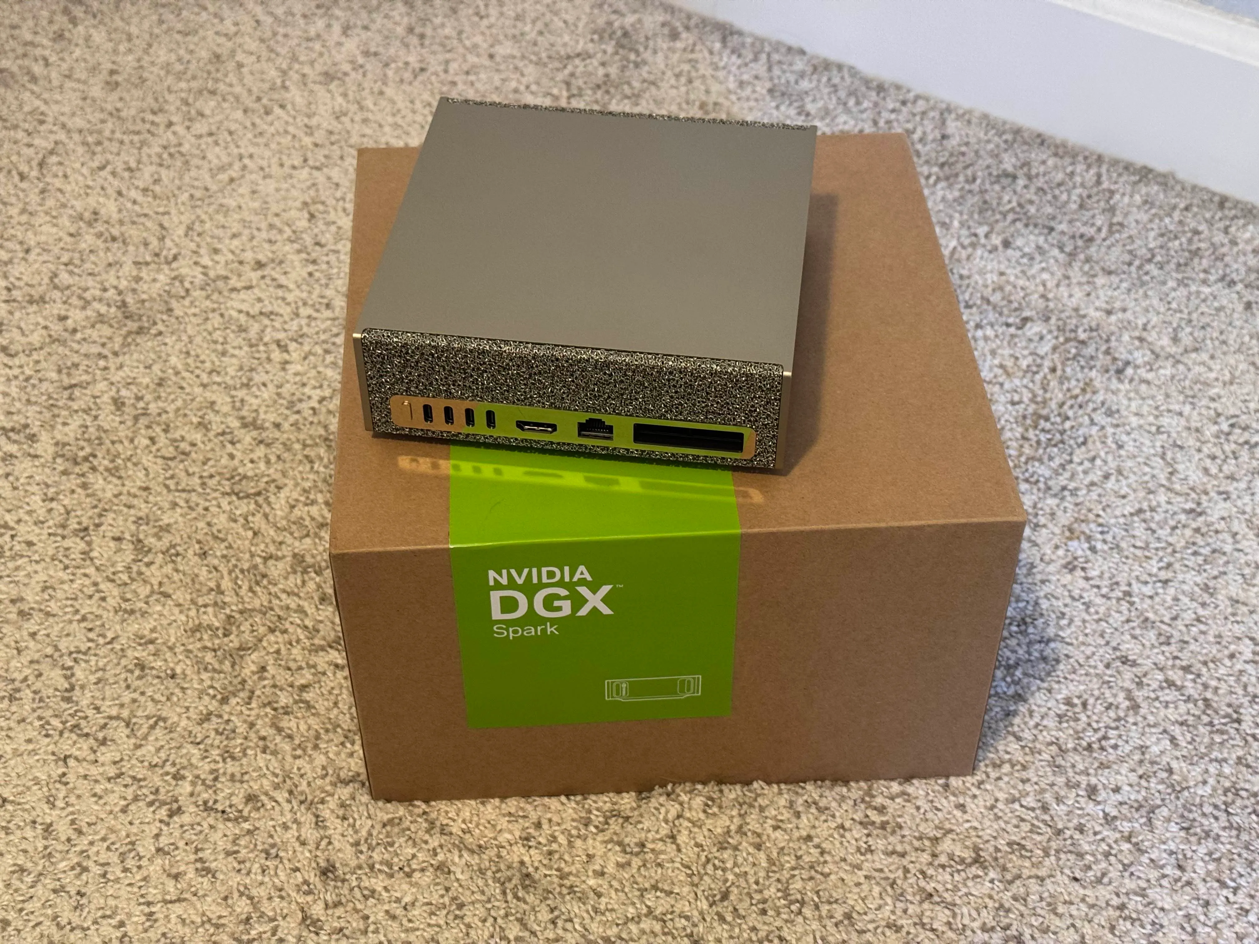 A gaudy, gold mini PC sitting on top of a box labeled "NVIDIA DGX Spark"